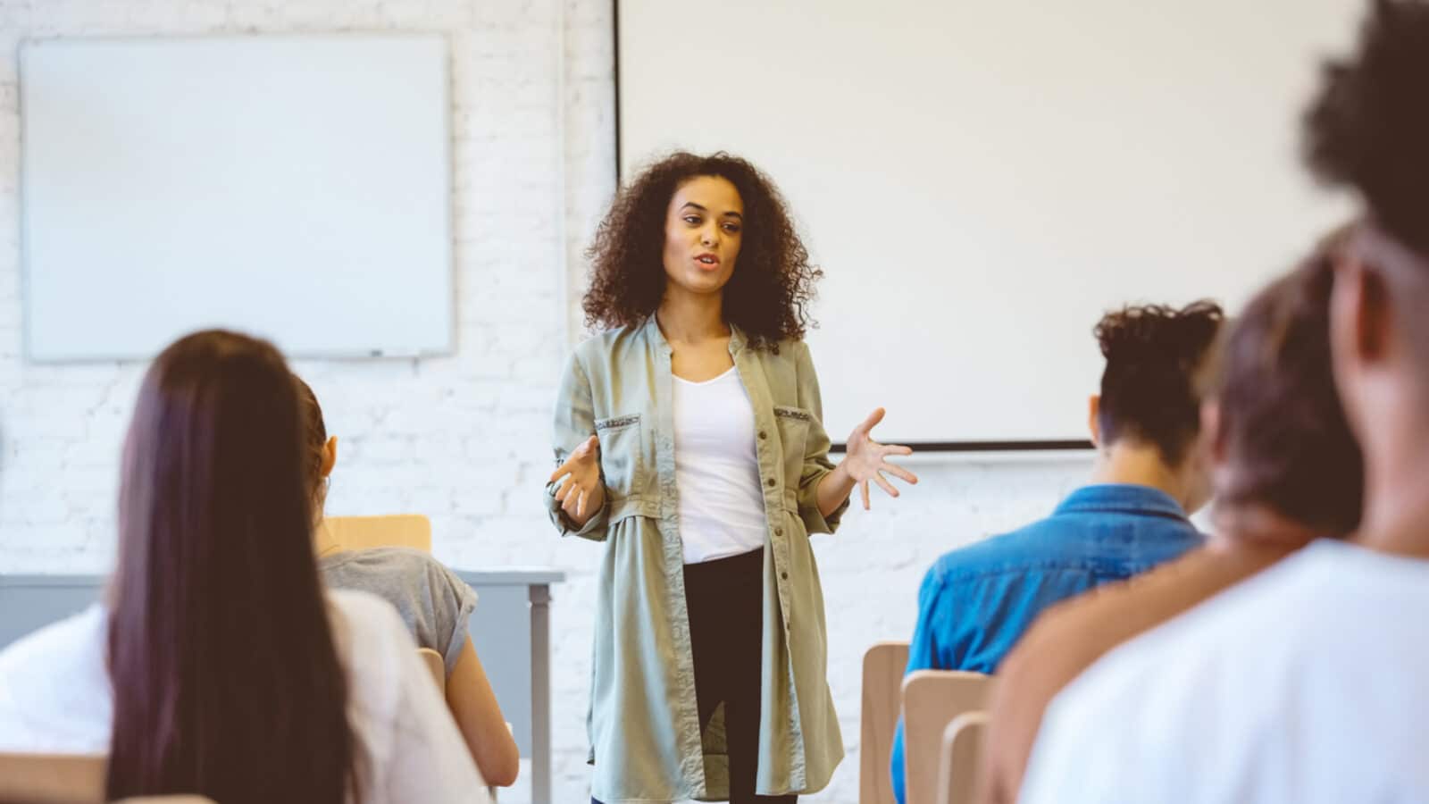 Young woman giving speech in classroom stock photo