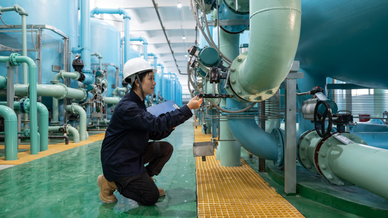 An Asian female prosecutor works in the workshop of a chemical plant